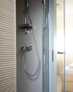 a shower with a shower head in a bathroom at Apartments Trzin-Mlake w FREE Parking in Trzin