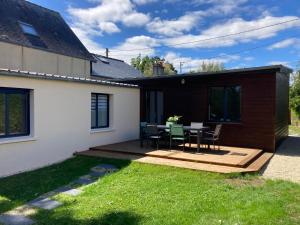 une arrière-cour avec une table et des chaises sur une terrasse dans l'établissement Cabane de pêcheurs avec spa au pied de l'étang, à Hédé