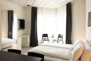 Habitación de hotel con cama, mesa y sillas en Apartments Trzin-Mlake w FREE Parking, en Trzin