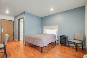 a bedroom with a bed and a table and a chair at Extended Stay America Select Suites - Charleston - North Charleston - I-526 in Charleston