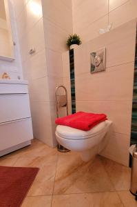 uma casa de banho com um WC com uma toalha vermelha em Comfort Warszawa em Varsóvia