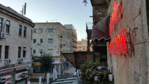 a city street with buildings and red neon signs at Zion Hotel in Jerusalem