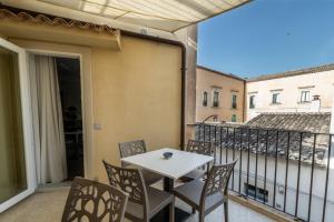 un patio con tavolo e sedie sul balcone. di Casa Melina a Scicli