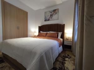 um quarto com uma cama grande e 2 candeeiros em DLX01 - Appartement Deluxe bien équipé- Centre Ville Oujda em Oujda