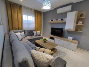 uma sala de estar com um sofá e uma televisão em DLX01 - Appartement Deluxe bien équipé- Centre Ville Oujda em Oujda