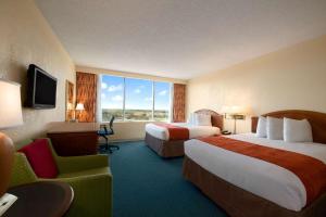 Ein Bett oder Betten in einem Zimmer der Unterkunft Ramada by Wyndham Kissimmee Gateway - Free Theme Park Shuttle