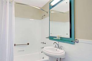 a bathroom with a sink, toilet and tub at The New Yorker, A Wyndham Hotel in New York