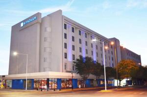 a large white building with a sign on it at Wyndham Executivo Culiacan in Culiacán