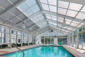 an indoor swimming pool with a glass ceiling and windows at Wyndham Garden Manassas in Manassas
