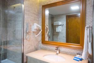 a bathroom with a sink and a shower and a mirror at Wyndham Batumi in Batumi
