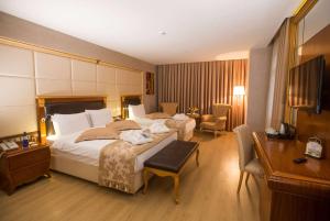 Habitación de hotel con cama grande y escritorio. en Wyndham Batumi, en Batumi