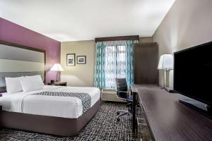a hotel room with a bed and a flat screen tv at La Quinta Inn by Wyndham Radford in Radford