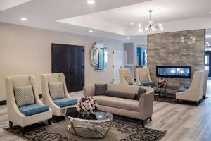 a living room with a couch and chairs and a tv at Wyndham Garden Kenosha Harborside in Kenosha