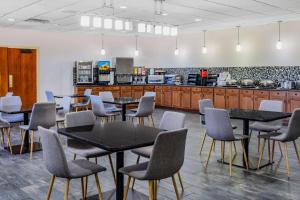 a cafeteria with tables and chairs and a counter at Wyndham Garden Kenosha Harborside in Kenosha