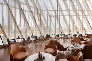 a large room with chairs and tables and windows at Wyndham Grand Manama in Manama