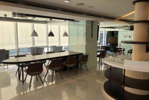 - une salle à manger avec des tables, des chaises et des fenêtres dans l'établissement Ramada Encore By Wyndham Hualien, à Hualien