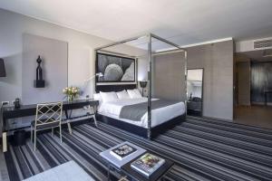 um quarto de hotel com uma cama e uma secretária em Wyndham Santiago Pettra em Santiago