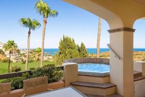 a hot tub on a balcony with palm trees and the ocean at Wyndham Residences Costa del Sol in Fuengirola