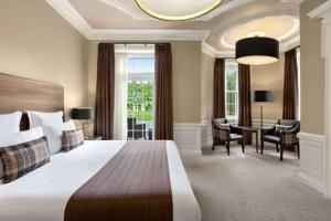 a hotel room with a bed, table and chairs at Wyndham Duchally Country Estate in Auchterarder