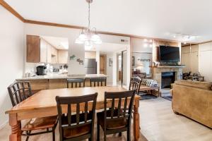 cocina y sala de estar con mesa de madera y sillas en Park Station Condominiums 234, en Park City