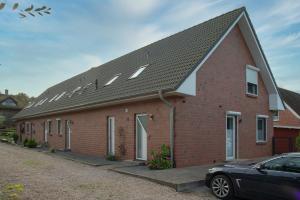 een rood bakstenen huis met een zwart dak bij Casa della Pera in Süssau