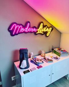 einen Schreibtisch mit Neonschild an der Wand in der Unterkunft Modern Living in Huningue