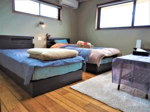 two beds in a room with two windows at CANOA GUEST HOUSE A room - Vacation STAY 50937v in Ikeda