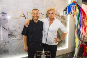 a man and a woman standing in front of a store at Cappo Aparthotel in Veliko Tŭrnovo