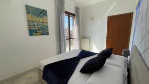 um quarto com uma cama com almofadas pretas e uma janela em DeHomes - Assago Forum em Buccinasco