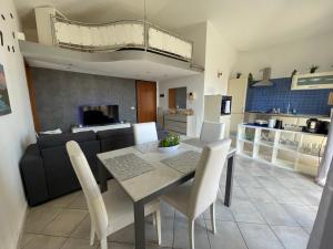 a dining room and living room with a table and chairs at DeHomes - Assago Forum in Buccinasco