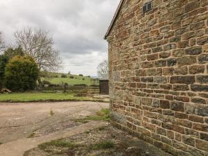 an old brick building next to a dirt road at Hideaway in Leek