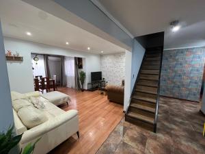 ein Wohnzimmer mit einem Sofa und einer Treppe in der Unterkunft Gran Apart Hotel Chillan - Monte Piedra - Factura Empresas in Chillán
