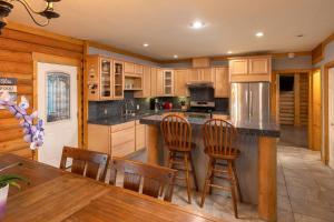 uma cozinha com armários de madeira e uma mesa e cadeiras em High Altitude Hideaway With Jacuzzi & Game Room em Big Bear City