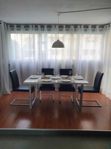 uma mesa de jantar com cadeiras e uma grande janela em Sunny apartment Benidorm em Cala de Finestrat