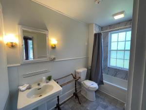 baño con lavabo y aseo y ventana en Stone Hearth Inn and Eatery, en Chester