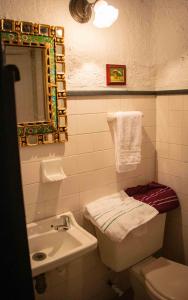 ein Badezimmer mit einem Waschbecken, einem WC und einem Spiegel in der Unterkunft La Ronda in Guatavita