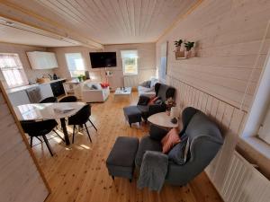 a living room with couches and a table and a kitchen at Adventure Eagle Cottege in Geysir