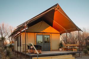a tiny house with an orange roof and a porch at El Cosmico in Marfa