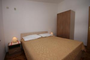 a small bedroom with a bed and a cabinet at Double Room Pag 6311b in Pag