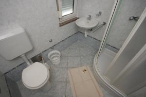 a bathroom with a toilet and a sink and a shower at Double Room Pag 6311b in Pag