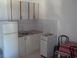 a small kitchen with a sink and a refrigerator at Apartment Metajna 6337b in Zubovići