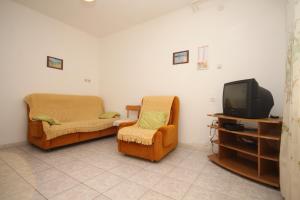 a living room with two chairs and a tv at Apartments by the sea Novigrad - 6979 in Novigrad Istria