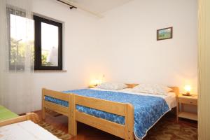 a bedroom with a bed with a blue comforter and a window at Apartments by the sea Novigrad - 6979 in Novigrad Istria
