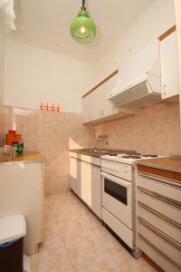 a kitchen with white cabinets and a stove top oven at Apartments by the sea Novigrad - 6979 in Novigrad Istria