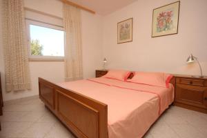 - une chambre avec un lit doté de draps orange et une fenêtre dans l'établissement Apartments with a parking space Valbandon, Fazana - 7228, à Fažana