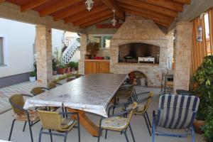 a patio with a table and chairs and a stone fireplace at Apartments with a parking space Novigrad - 7037 in Novigrad Istria