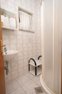 La petite salle de bains est pourvue d'un lavabo et de toilettes. dans l'établissement Apartments with a parking space Novigrad - 7037, à Novigrad