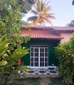 uma casa verde com uma janela e uma palmeira em Pousada & Restaurante do Vaninho em Januária
