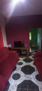 uma sala de estar com um sofá vermelho e uma mesa em Pousada & Restaurante do Vaninho em Januária