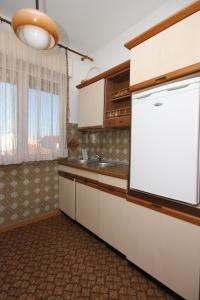 a kitchen with a white refrigerator and a sink at Apartments with a parking space Valbandon, Fazana - 7215 in Štinjan